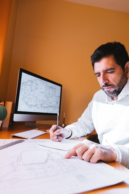 Foto arquiteto desenhando um plano enquanto está sentado na mesa