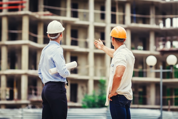 Arquiteto e construtor discutindo no canteiro de obras