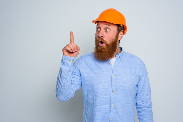 Arquiteto isolado surpreso com barba e capacete laranja