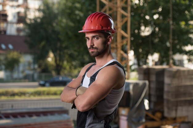 Foto arquiteto masculino bem sucedido em um canteiro de obras com os braços cruzados