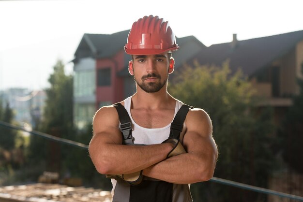 Arquiteto masculino bem sucedido em um canteiro de obras com os braços cruzados