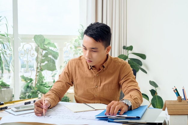 Arquiteto masculino bonito asiático trabalhando no escritório