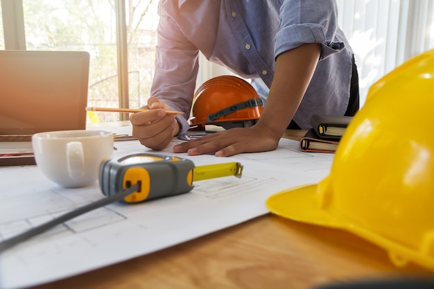 Foto arquiteto ou engenheiro trabalhando na planta no escritório, conceito arquitetônico