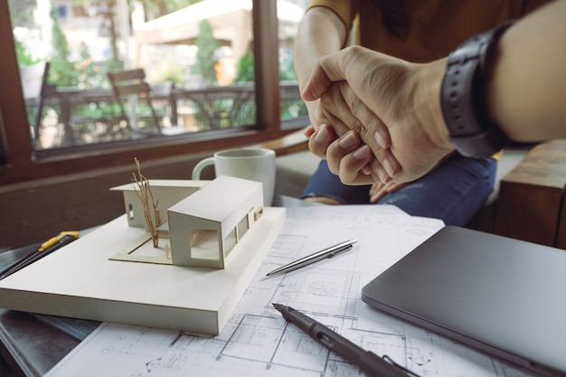 Foto arquiteto trabalhando em papel de desenho e modelo arquitetônico