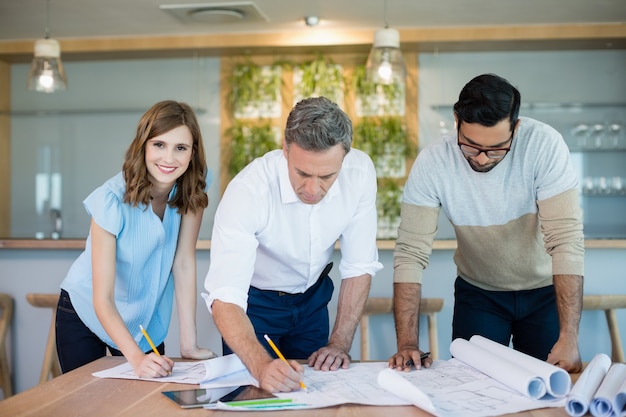 Arquitetos trabalhando na planta da sala de conferências