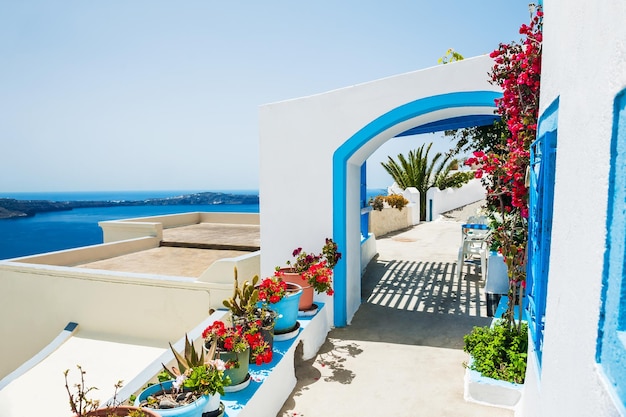 Arquitetura branca e flores na rua. Ilha de Santorini, Grécia. Bela paisagem de verão.