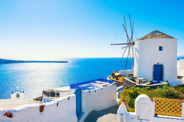 Arquitetura branca na ilha de Santorini, Grécia Moinho de vento na cidade de Oia em um dia ensolarado