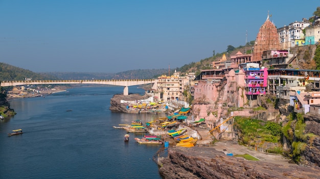 Arquitetura da cidade de Omkareshwar, Índia, templo hindu sagrado. Santo rio Narmada, barcos flutuantes.