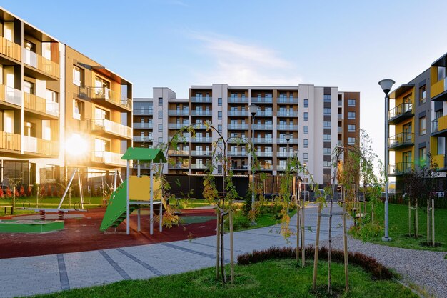 Arquitetura de fachada de casa residencial de apartamento com parque infantil e instalações ao ar livre. Céu azul ao fundo. Com luz do sol