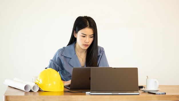 Arquitetura de jovem empresária asiática no escritório trabalhando com laptop de computador Jovem arquiteta asiática trabalhando em projeto Mulher de arquitetura trabalhando laptop no espaço de trabalho