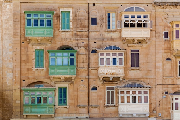 Arquitetura de Malta a fachada da casa com janelas de madeira coloridas e uma varanda