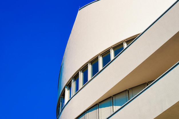 Arquitetura do edifício de escritórios de negócios da cidade moderna de Leibnitz, na Áustria. Exterior e horizonte de arranha-céus corporativos urbanos. Fachada futurista com design Windows. Fundo do céu azul.