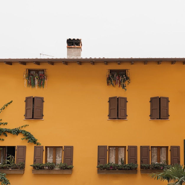 Arquitetura italiana histórica Edifício rústico europeu tradicional com paredes laranja coloridas, persianas e janelas de madeira Conceito de viagem de férias de verão estético