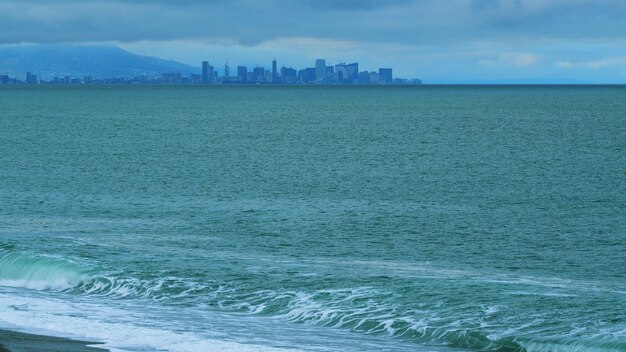 arranha-céus cidade de batumi água calma ondulando sob o horizonte sombrio ainda