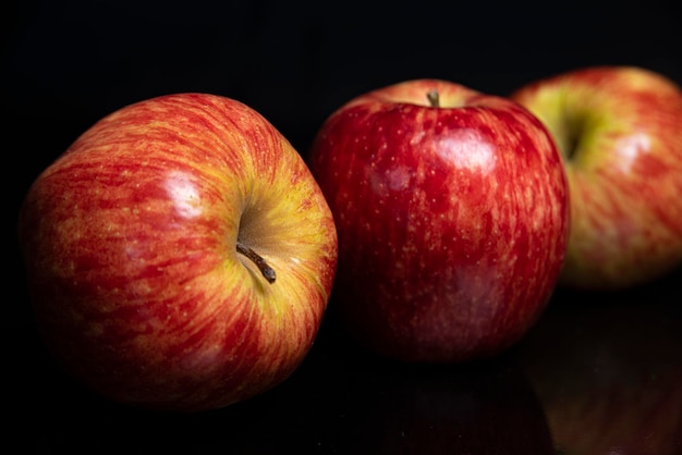 Arranjo com frutas em uma superfície preta brilhante com fundo preto