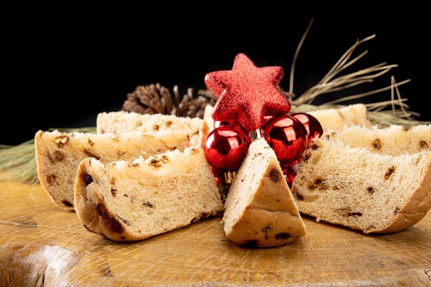 Arranjo com rodelas de panetone, pinhas e bolas de natal em madeira rústica