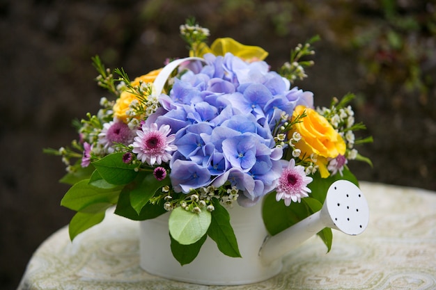 Arranjo de flores de hortênsia no regador. Decoração de casamento. Decoração de verão ao ar livre.