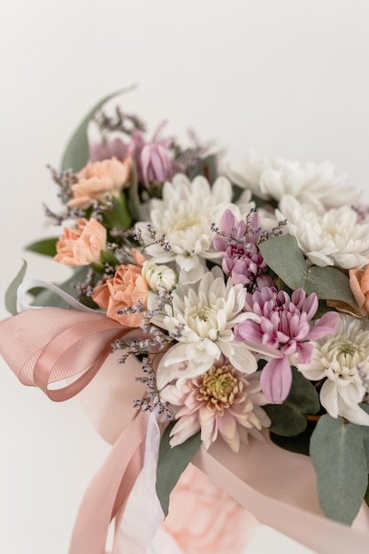 Arranjo de flores em um copo com um canudo em uma limonada de flores de fundo branco