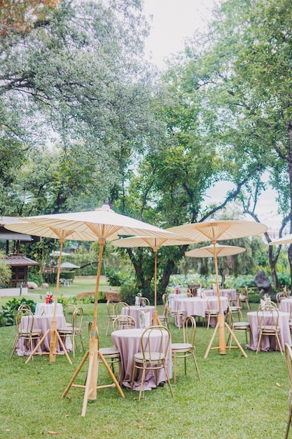 Arranjo de flores para casamento de verão feito de rosas e galhos verdes em uma mesa de jantar no vidro do restaurante e pratos no restaurante do lado de fora em um dia ventoso com efeito de grão de filme