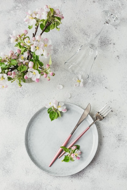 Arranjo de mesa de primavera com galhos de macieiras em flor e flores na mesa