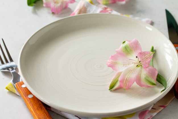 Arranjo de mesa de primavera ou dia das mães talheres de prato e guardanapo na mesa de pedra branca copiar espaço
