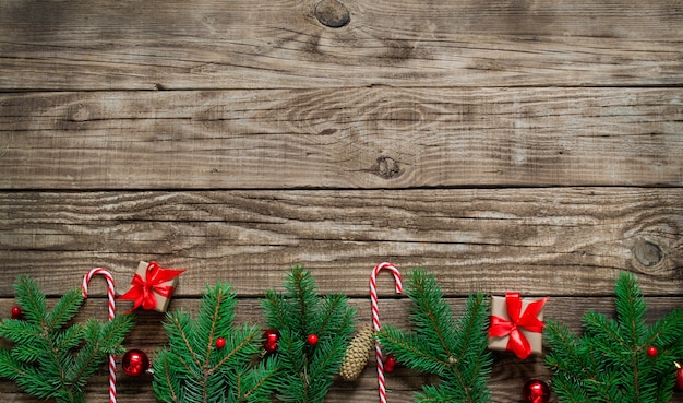 Arranjo de Natal brilhante com galhos de pinheiro, bastões vermelhos doces, bolas de Natal vermelhas