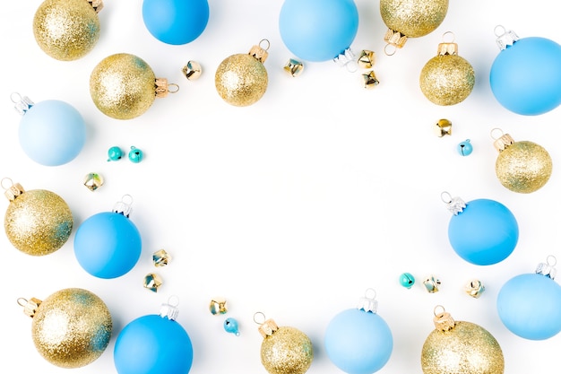 Arranjo elegante, moldura de bolas de Natal azuis e douradas sobre fundo branco. Camada plana, vista superior