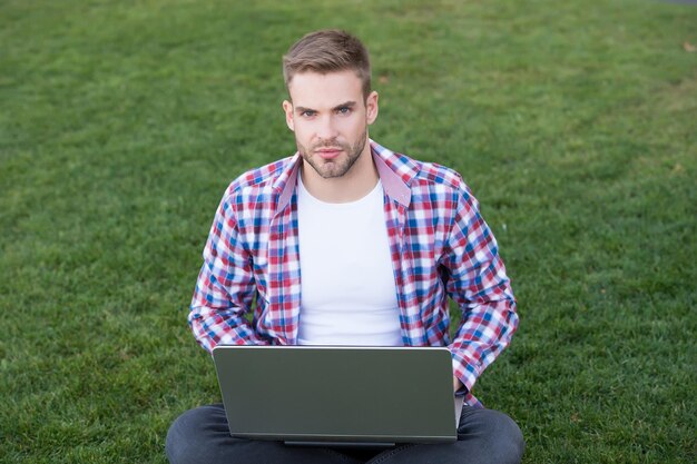 Arranque de negócios. A geração milenar cria negócios. Negócios modernos. Tecnologias modernas. Aluno estudando no Prado. Comunicações online. Surfando na internet. Homem olhando a tela do laptop. Desenvolvedor talentoso.