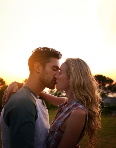 Arrastrados por el romance, una foto recortada de una cariñosa pareja joven al aire libre