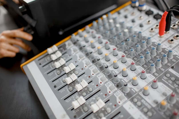 Foto el arreglista musical masculino trabaja con un amplificador de sonido que está componiendo una canción en un piano midi y un equipo de audio en un estudio de grabación digital