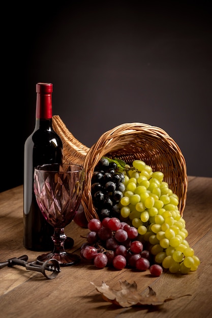 Foto arreglo de cuerno de la abundancia con deliciosas comidas y una botella de vino.