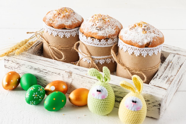 Arreglo decoración Feliz Pascua concepto de fondo de vacaciones. Tortas de Pascua en caja de madera con huevos tejidos a mano. Colores pastel.