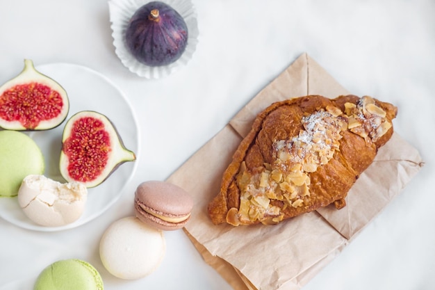 Arreglo estético de croissant de higos, almendras y pasta en una vista superior de fondo blanco