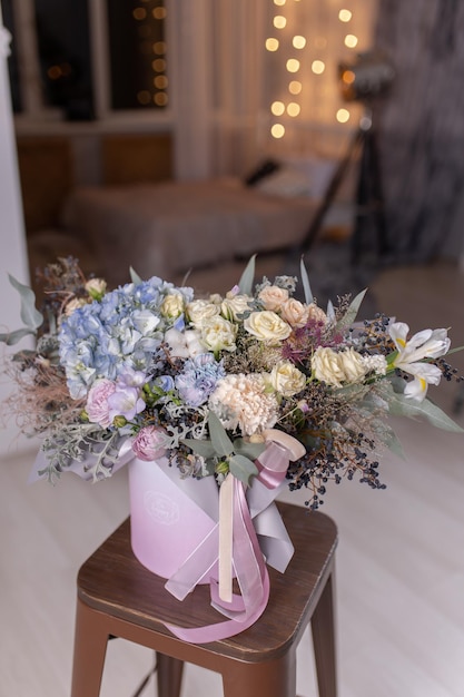 Arreglo floral en caja redonda con peonias hortensias azules y rosas