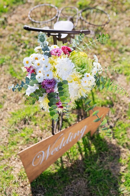 Arreglo floral en la hierba con un cartel de boda