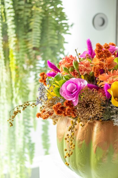 Foto arreglo floral de rosas dentro de calabaza decorado para un halloween diferente