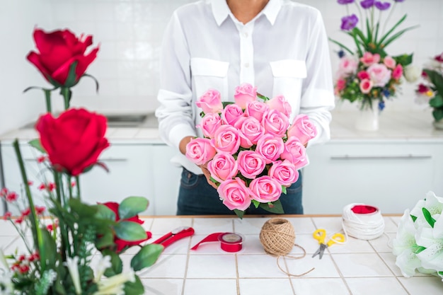 Arreglo de flores artificiales, floristería joven trabajo haciendo organización de flores artificiales de bricolaje