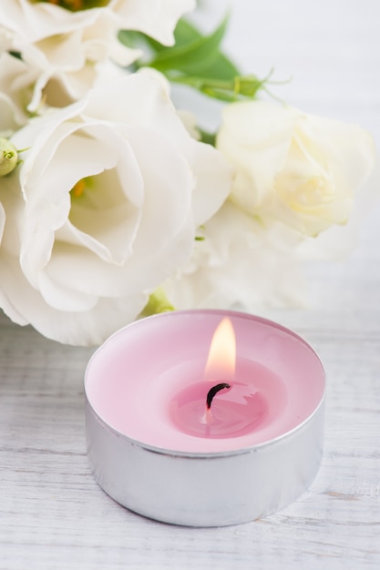 Arreglo de flores de eustoma blanco y vela rosada