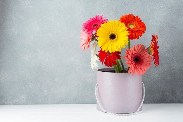 Arreglo de flores de gerbera margarita en un cubo