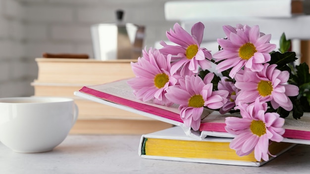 Foto arreglo con flores y libros.