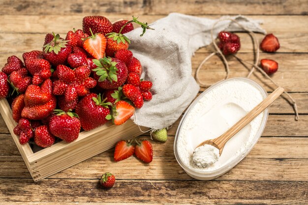 Arreglo con fresas frescas en la mesa de madera