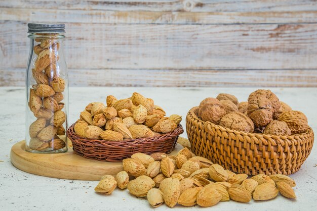 Arreglo de frutos secos, almendras y nueces en rústica mesa de madera vieja