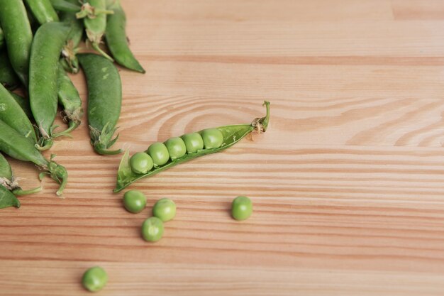 Arreglo de guisantes verdes frescos en la mesa de madera