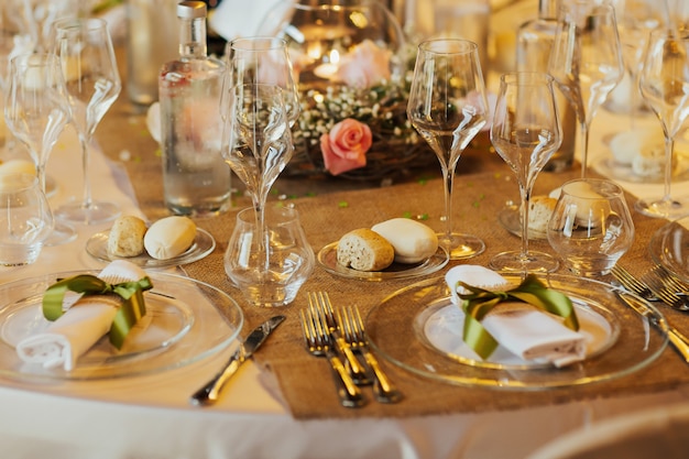 Arreglo de mesa de boda romántica con mantel beige y servilletas.