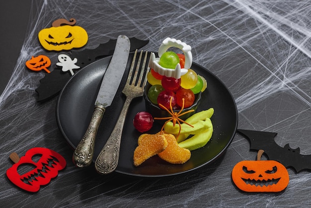 Foto arreglo de mesa composición festiva tradicional para la fiesta de halloween accesorios de temporada divertidos decoración de otoño casera luz dura sombra oscura piedra negra fondo de hormigón espacio plano de copia