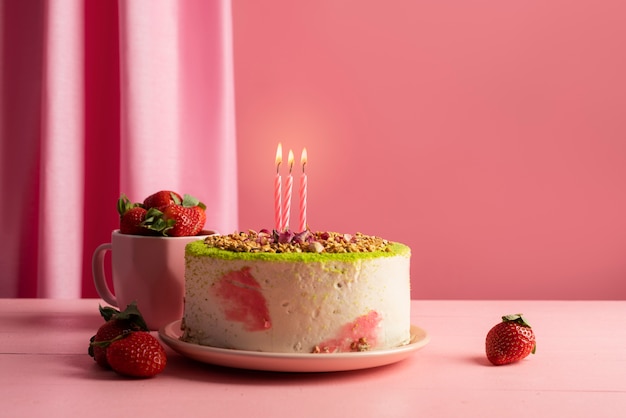 Foto arreglo de mesa para evento de cumpleaños con pastel y fresas.