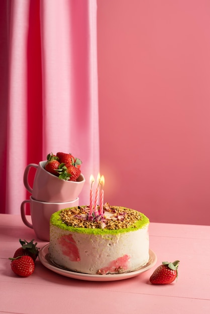 Foto arreglo de mesa para evento de cumpleaños con pastel y fresas.