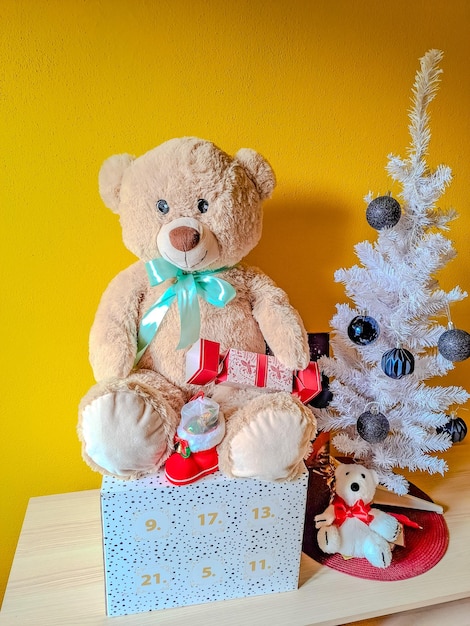 Arreglo de Navidad colgando decoraciones rojas regalos bajo el árbol de Navidad