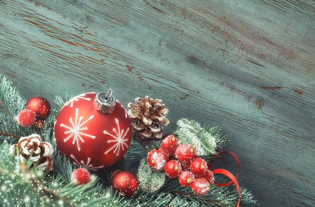 Arreglo navideño con adornos, ramas de abeto y bayas heladas