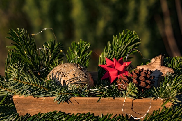 Un arreglo navideño con estrellas ramas de abeto y una pelota con las palabras frohes fest